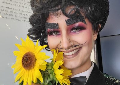 Close-up of Cyril Cinder in back suit with a sunflower.