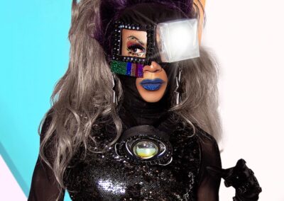 Pepper wearing a futuristic black bodysuit with mask, and a white light box covering her left eye.