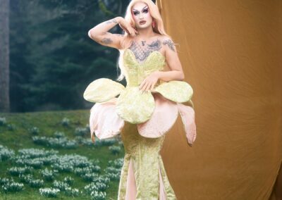 Van Goth wearing a pale green and pale pink flower gown with fabric petals at the hips.