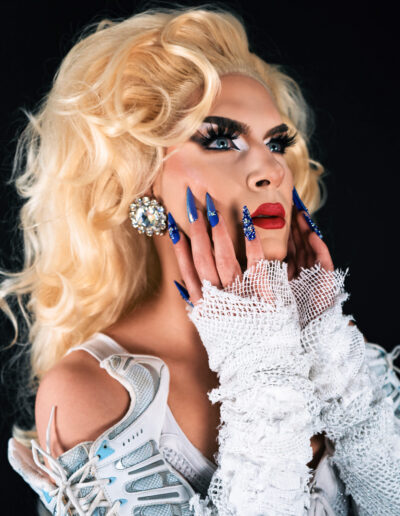 Bust view of Vanity Affair looking up to the right, wearing an outfit made of white sneakers.