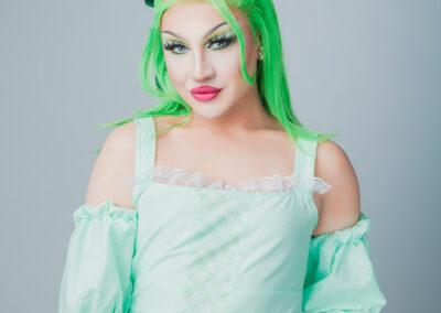 Zara Matrix wearing a mint green frilly shirt and neon green wig.