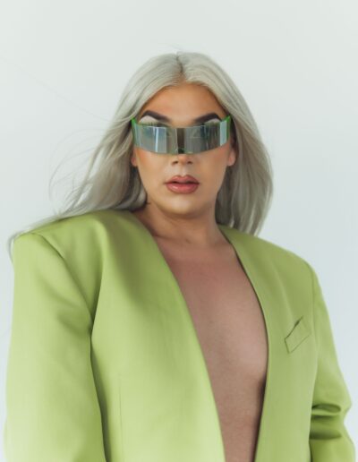 Chelazon Leroux in a green jacket, gazing intensely into the camera with reflective single-lensed sunglasses.