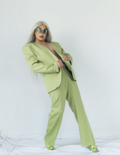 Chelazon Leroux in a green jacket and reflective single-lensed sunglasses, leaning back.