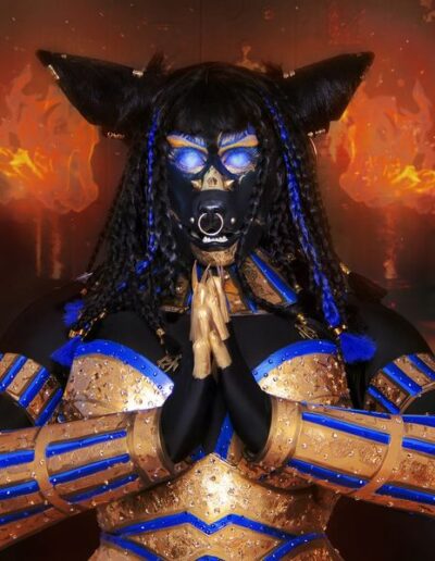 Close up view of Halal Bae dressed as Anubis, her hands clasped together just under her face.