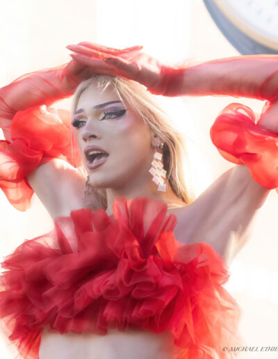 Liquorice wearing a red ruffly crop top with matching sheer ruffled gloves.