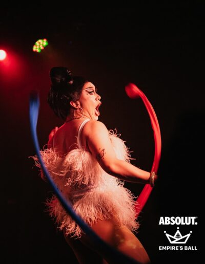 Star dancing in a white rhinestone and feather corset.