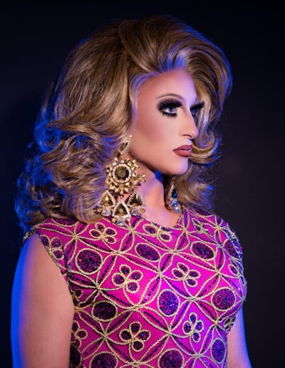 Aliya Holmes looking to the right of the camera wearing a pink dress with gold and purple embroidery.