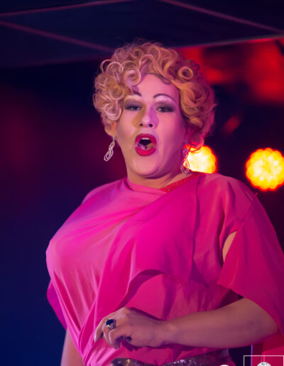 Geena Hayze performing in a hot pink draped dress.