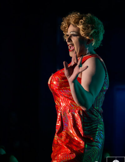 Geena Hayze performing in a red and gold tiger striped dress.