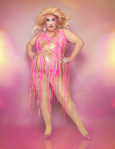 Dulce posing confidently in a shimmery pink fringed bodysuit.